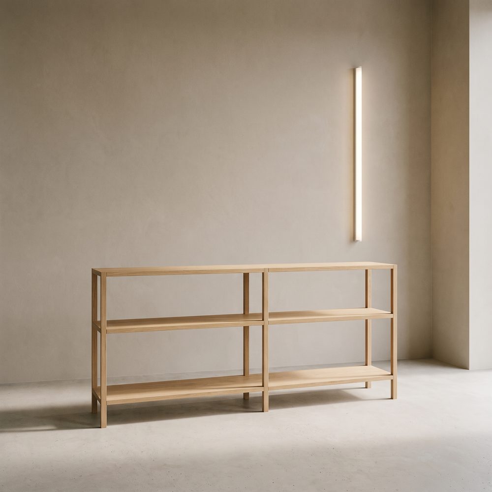 A low oak shelving unit against a plaster wall